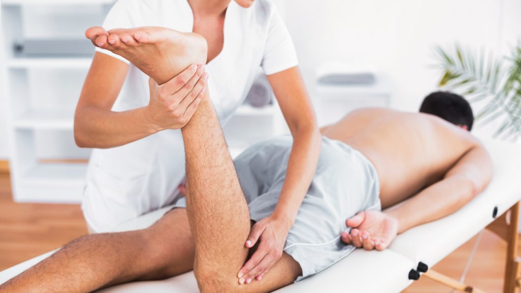 ماساژ پا و مفصل زانو توسط یک ماساژور حرفه‌ای برای رفع خستگی و تنش عضلانی
