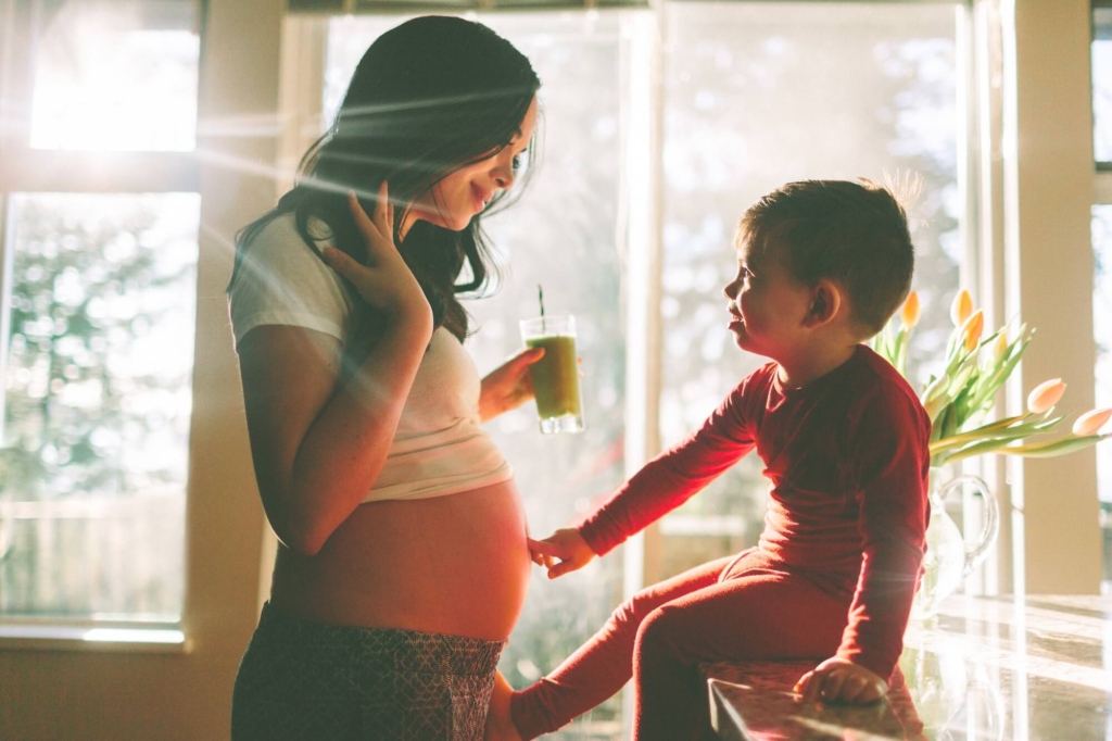 زن باردار با کودک کنار پنجره